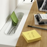 Organisierter Arbeitsbereich mit Laptop, Notizbüchern, Stiften und Haftnotizen. Der Schreibtisch verfügt über Fächer und eine Kabelführungsschale.
