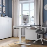 Modernes Homeoffice mit verstellbarem Schreibtisch, Fenster, Stuhl und minimalistischem Dekor.