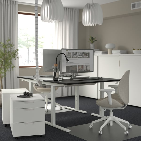 Modernes, sauberes Büro: weißer höhenverstellbarer MITTZON-Schreibtisch, grauer Stuhl, schlankes Design, Monitor und Aufbewahrungseinheiten.