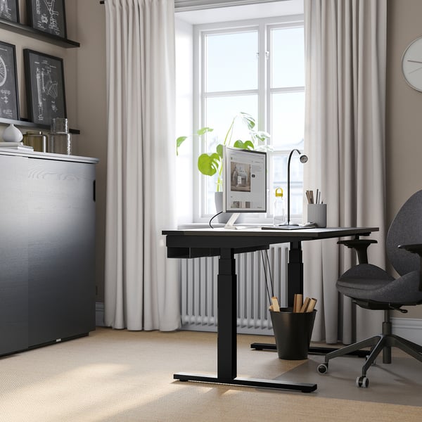 Modernes Homeoffice mit Stehpult am Fenster, Stuhl, Monitor, Pflanze und Schrank.
