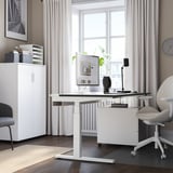 Modernes Homeoffice mit weißem MITTZON Sitz-Steh-Schreibtisch, ergonomischem Stuhl und Aufbewahrungsschrank.