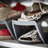 Ausstellung von Sandalen mit Leopardenmuster auf grauen MURVEL Schuhregalen.