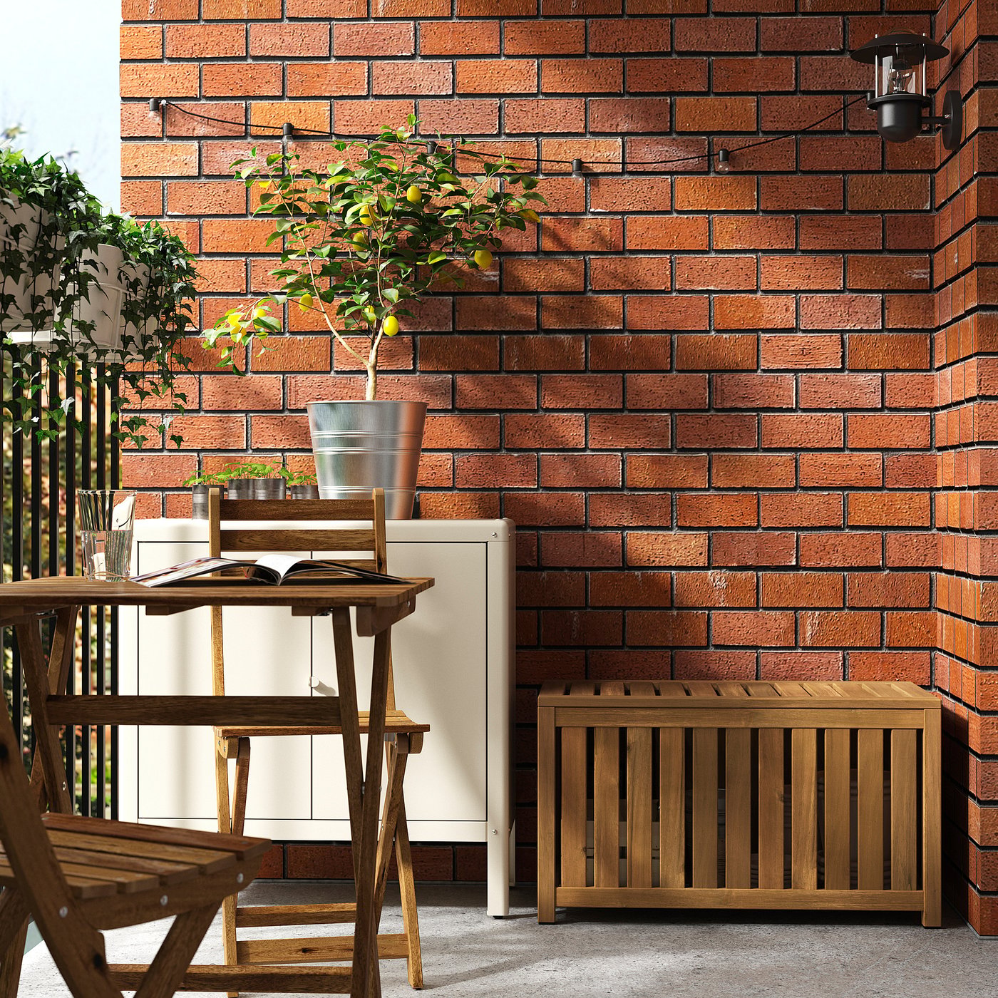 Balkon mit roter Backsteinwand, Holzmöbeln, Zitronenbaum und Aufbewahrungsbox. Kleines, ordentliches Setup.