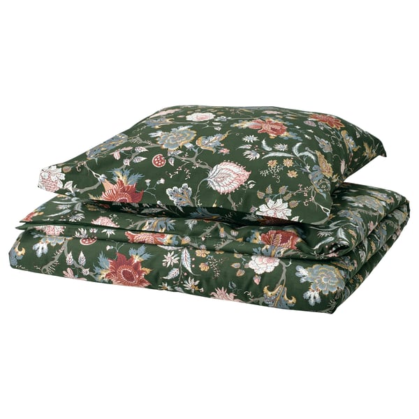Gestapeltes Set aus grünen Blumenbettdecken und -kissen mit komplizierten Designs.