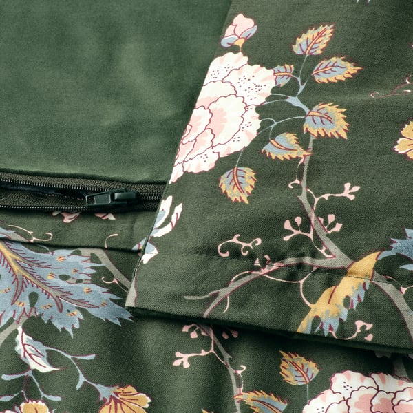 Bettbezug mit Blumenmuster und Reißverschlüssen an der grünen und einfarbigen Seite, der strukturierten Stoff zur Geltung bringt.