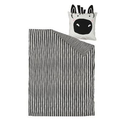 Kissen und Decke mit Zebra-Motiv: schwarz-weiße Streifen, weicher Stoff, verspieltes Design.