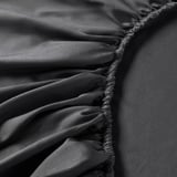 Nahaufnahme eines luxuriösen, glänzenden Bettwäschestoffs mit eleganten, gerafften Details, die seine weiche, satingewebte Textur zur Geltung bringen.