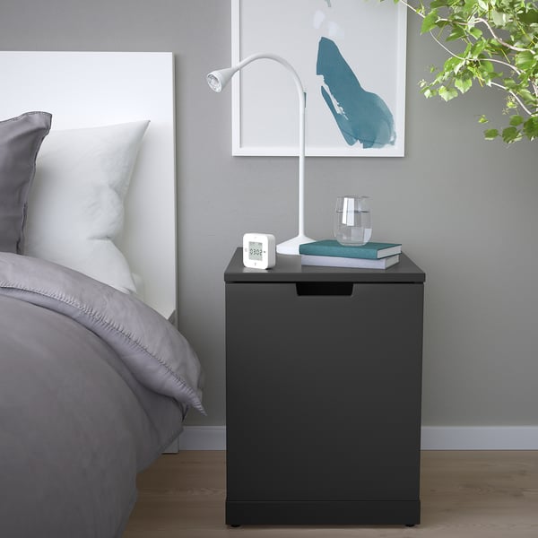 Modernes Schlafzimmer mit IKEA NORDLI Nachttisch, Lampe, Buch, Glas und Pflanze.