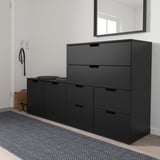 Schwarze NORDLI-Schubladen im Eingangsbereich, 3+2 Einheiten auf Teppich, Garderobe in der Nähe. Oder schwarze NORDLI-Schubladen, 5 Schubladen im Eingangsbereich, Garderobe, grauer Teppich.