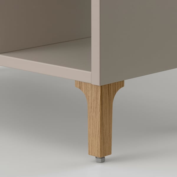 Moderner Schrank mit glatter, beiger Oberfläche und robusten Holzbeinen, die von hochwertiger Verarbeitung zeugen.