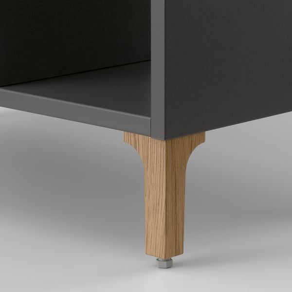 Holzbeine tragen einen schlanken, modernen Schrank. Die solide Bauweise sorgt für Stabilität.