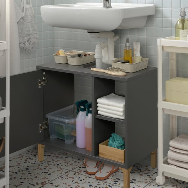 Moderne Badezimmereinrichtung mit einem grauen Norsalven-Waschbeckenschrank. Es verfügt über Stauraum an der Tür, offene Regale mit Toilettenartikeln und ein Waschbecken obendrauf.