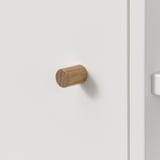 Kleiner Holzhaken an weißer Wand. Einfaches, natürliches und minimalistisches Design. Ideal zum Aufhängen von Handtüchern oder Accessoires.