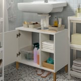 Weißer Badezimmerschrank unter dem Waschbecken mit offener Tür, in dem Handtücher, Sprays und Behälter angeordnet sind.