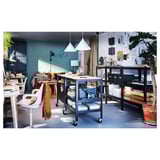 Modernes Home Office mit blauen ODGER-Stühlen, Holztischen, Pflanzen und heller Beleuchtung.