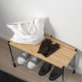 Schuhregal aus Holz mit Handschuhen und Tasche.