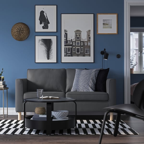 Modernes Wohnzimmer mit grauem PÄRUP-Sofa, Galeriewand und Schwarz-Weiß-Dekor.
