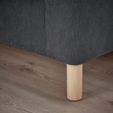Nahaufnahme eines modernen Sofabeins. Schlankes Design, robustes Holz, ergänzt stilvolle Wohnkultur.