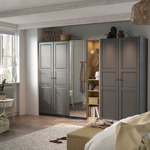 Modernes Schlafzimmer mit grauem PAX-Kleiderschrank , Glas- und Holzregalen, minimalistischer Einrichtung.