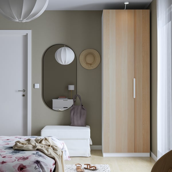 Minimalistisches Schlafzimmer mit modernem PAX-Kleiderschrank, geblümter Bettwäsche und stilvoller Einrichtung.