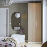 Minimalistisches Schlafzimmer mit modernem PAX-Kleiderschrank, geblümter Bettwäsche und stilvoller Einrichtung.