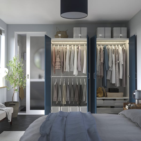 Schlafzimmer mit offenem Kleiderschrank mit Kleidung, Regalen und Accessoires. Der Kleiderschrank verfügt über Innenbeleuchtung und verstellbaren Stauraum.