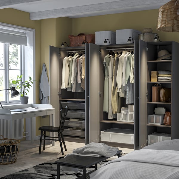 Organisiertes Schlafzimmer mit PAX-Kleiderschrank, Schreibtisch, Stuhl und Fensterpflanze.