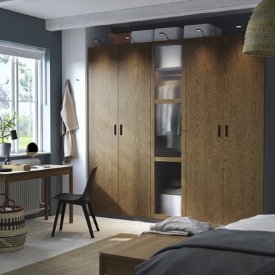 Schlafzimmer mit PAX-Kleiderschränken, Stuhl, Schreibtisch, Pflanze.