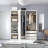 Modernes Schlafzimmer mit offenem Kleiderschrank, ordentlich organisierter Kleidung, heller Bettwäsche.