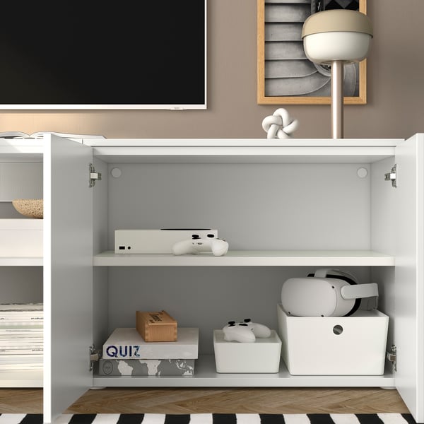 Weißes PLATSA-Regal mit Spielkonsole, Controllern, VR-Headset und Aufbewahrungsboxen. Sicher an der Wand montiert.