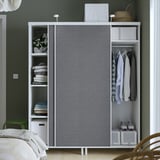 Moderner Kleiderschrank mit Schiebetüren und offenen Regalen, in denen organisierte Kleidung und Aufbewahrungsboxen präsentiert werden.
