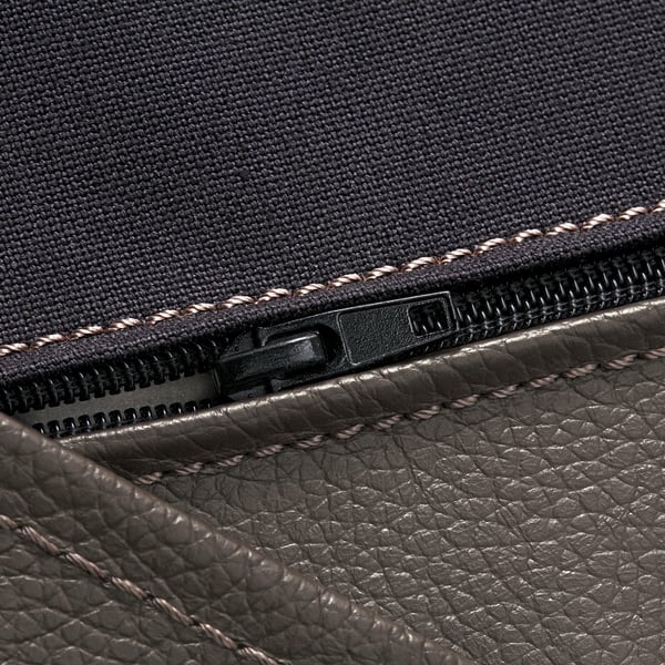 Nahaufnahme des Reißverschlusses des POÄNG Sessels mit hochwertigen Nähten und robuster Textur aus Stoff und Leder.