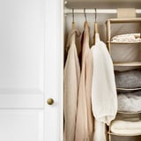 Kleiderschrank mit hängenden Bademänteln und gestapelten gefalteten Handtüchern.