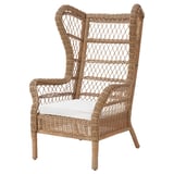 Ein beigefarbener RISHOLMEN Ohrensessel aus Korbgeflecht mit hoher Rückenlehne und gepolsterter Sitzfläche. Der Stuhl besteht aus Kunststoff, Rattan und Stahl und ist für den Außenbereich konzipiert.