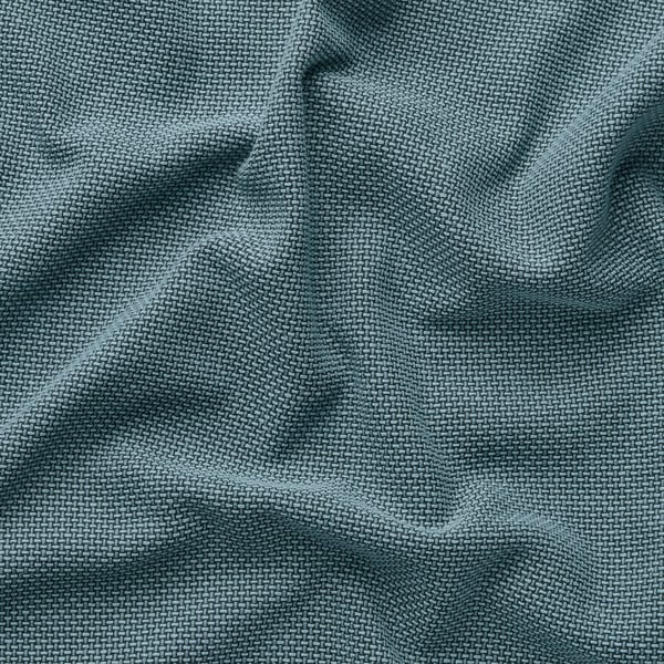 Nahaufnahme eines plüschigen, strukturierten grünen Sofastoffs, der seine filigrane Gewebe und die weiche Textur hervorhebt.
