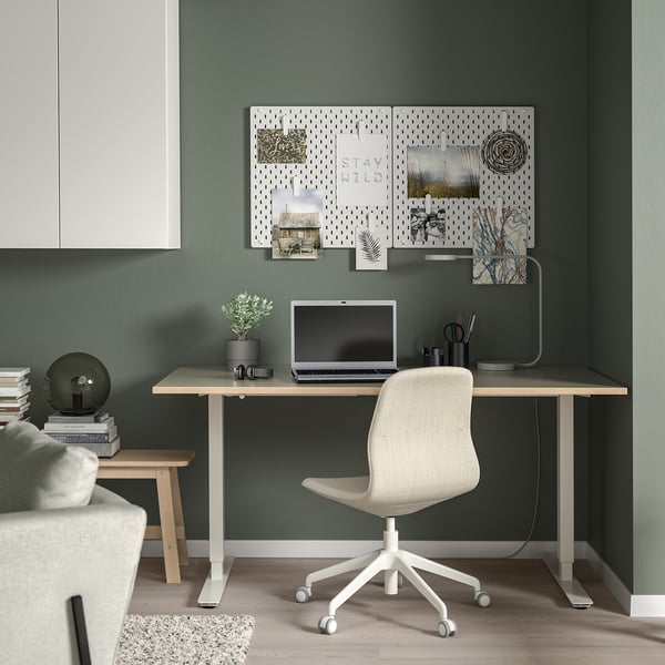 Minimalistisches Homeoffice: grüne Wand, Schreibtisch, Stuhl, Laptop, Stecktafel.