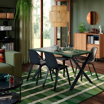 Moderner Speisesaal mit SKÅLSTA-Tisch , schwarz, rechteckig, umgeben von schwarzen Stühlen. Robustes, stilvolles Design; Erdige Töne passen zur Dekoration.