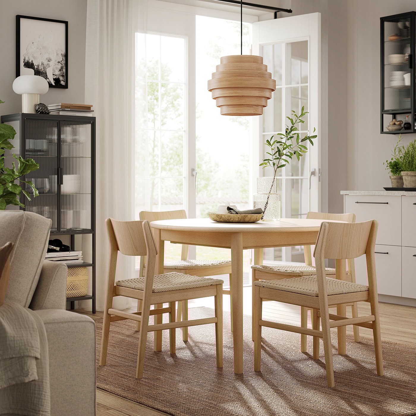 Modernes Esszimmer mit SKANSNÄS Holztisch und Stühlen, hellem Holz, runder Form, skandinavischem Design, Hängeleuchte, Pflanzen, Regalen.