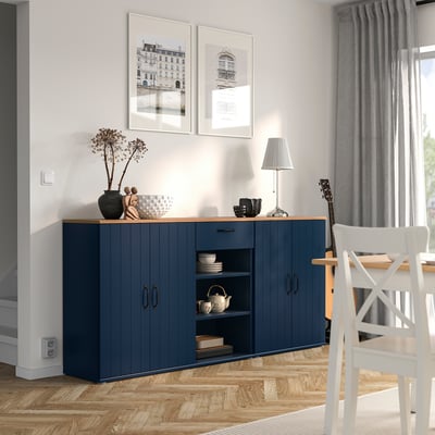 Modernes Esszimmer mit blauem SKRUVBY Sideboard, weißem Stuhl, Holzboden, grauen Vorhängen, Fotos und Lampe.