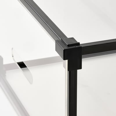 Eine durchsichtige SKUFFEN-Schuhaufbewahrungsbox mit dunklem Metallrahmen, quadratischer Form und transparentem Design.