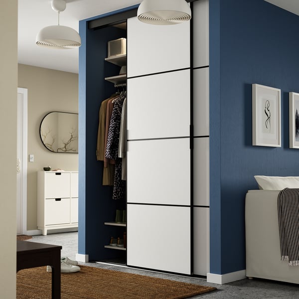 Moderner Kleiderschrank mit SKYTTA-Schiebetüren, Rahmen aus Faserplatten und Aluminium, organisierter Stauraum, blauer Wandkontrast.