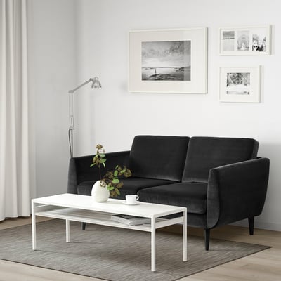 Modernes Wohnzimmer mit SMEDSTORP-Sofa, Couchtisch, Lampe und Kunstwerken.
