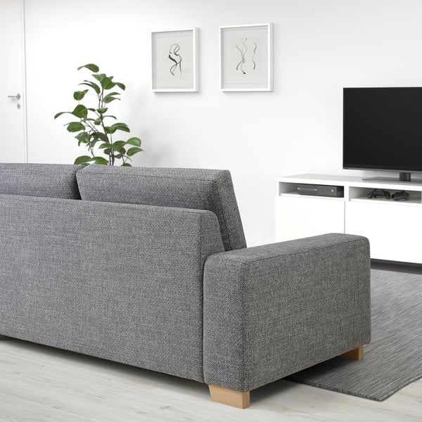 Graues SÖRVALLEN 3-Sitzer-Sofa in minimalistischem Wohnzimmer mit TV & Pflanze.
