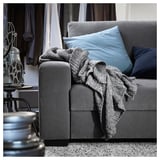 Modernes graues Sofa mit blauen Kissen und grauer Decke, Vintage-Filmrollendekoration.