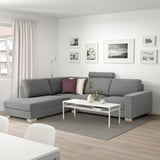Modernes Wohnzimmer: graues SÖRVALLEN L-förmiges Sofa, weißer Couchtisch, Kunstwand, großes Fenster mit Lichtvorhängen.
