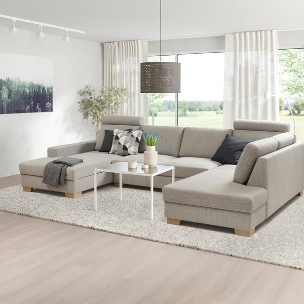 Modernes graues SÖRVALLEN-Sektionssofa in minimalistischem Raum mit Chaiselongue, Couchtisch, Teppich und Lampen.