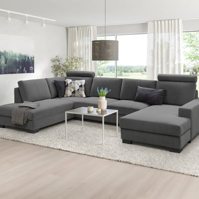 Modernes minimalistisches Wohnzimmer: U-förmiges graues SÖRVALLEN-Sofa, große Fenster, weißer Teppich, weißer Couchtisch.