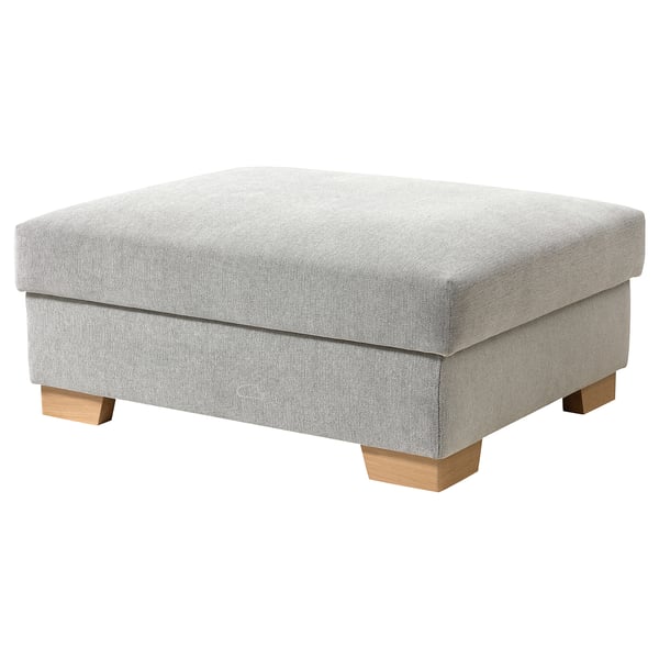 Ein grauer SÖRVALLEN Fußhocker mit Holzbeinen und Stauraum.