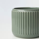 Vase aus grünem Feinsteinzeug mit vertikalen Rillen.