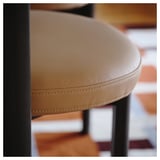 Nahaufnahme eines hochwertigen Ledersessels mit detaillierten Nähten und robustem Holzgestell.